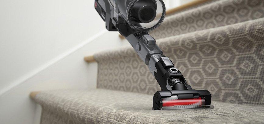 A hoover emerge pet vacuum cleaner being used on carpeted stairs with a motorized tool attachment