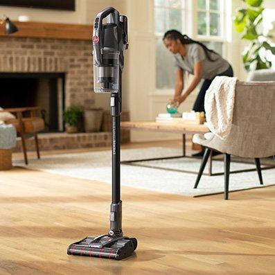 A hoover emerge pet self-standing vacuum cleaner standing upright on a hardwood floor in a living room, demonstrating its ease of use and convenience