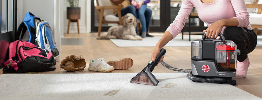 Cleanslate portable spot cleaner is being used to remove muddy footprint stains from a light colored carpet