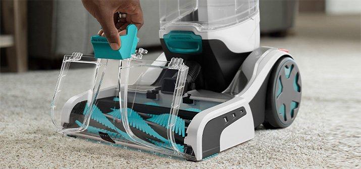 Someone removing the brushroll from a Hoover automatic carpet cleaner, showcasing easy maintenance and advance cleaning solutions.