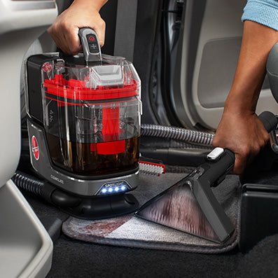 Cleanslate portable spot cleaner shown in action with led spotlight thoroughly cleaning carpet car mats   