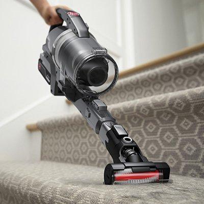 A hoover emerge pet vacuum cleaner being used on carpeted stairs with a motorized tool attachment