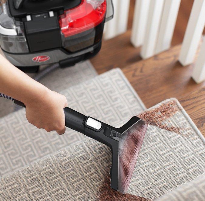 Hoover Cleanslate portable carpet cleaner removing tough, colored stains from stairs, showcasing its powerful stain removal capabilities