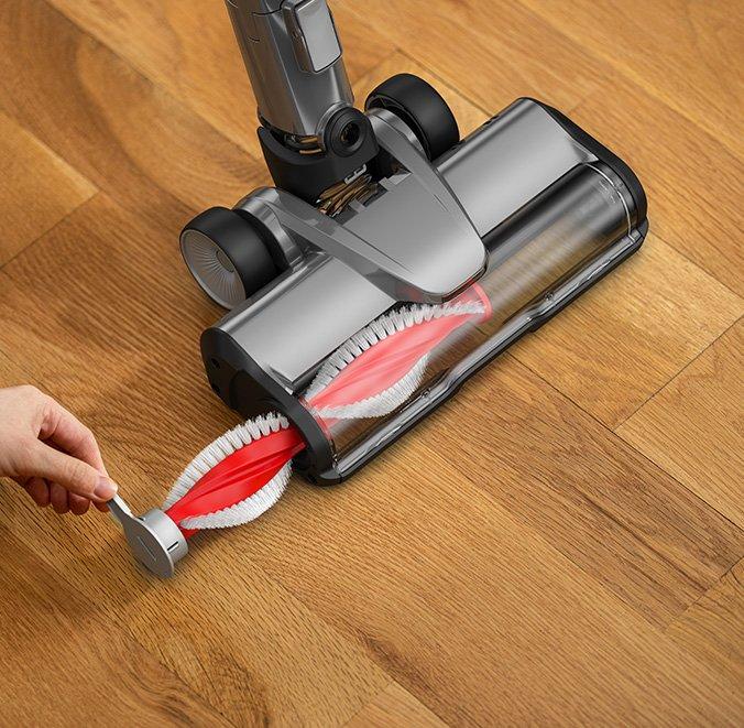 Close up of someone removing the brush roll from the vacuum head for convenient maintenance.