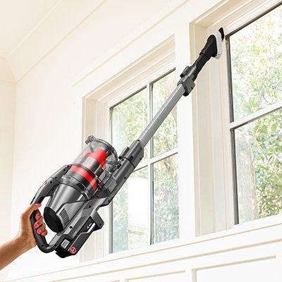 Hoover cordless vacuum cleaner 2 in 1 tool being used to dust the hard to reach window sill.