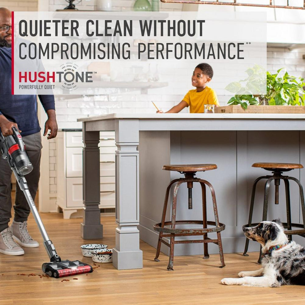 Man using his ONEPWR emerge cordless vacuum cleaner to vacuum spilled pet food in the kitchen as his child and dog watch.  The text highlights its Hushtone feature which allows quieter clean without compromising performance. 