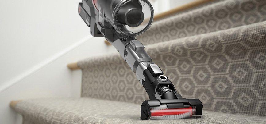 A hoover emerge pet vacuum cleaner being used on carpeted stairs with a motorized tool attachment