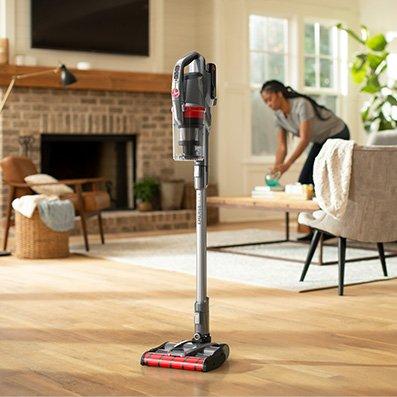 A hoover emerge pet self-standing vacuum cleaner standing upright on a hardwood floor in a living room, demonstrating its ease of use and convenience