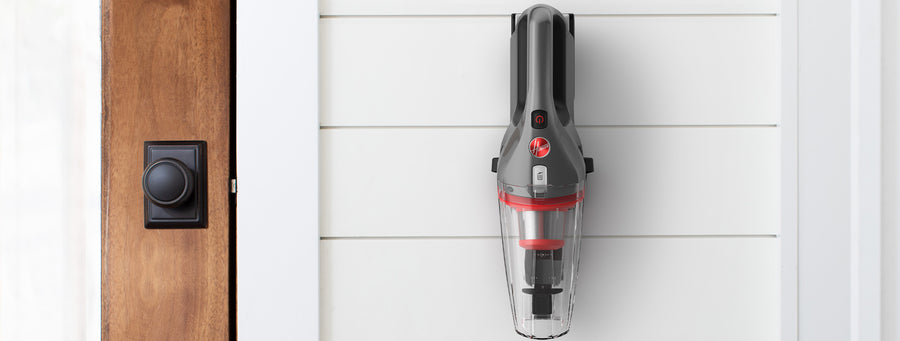 ONEPWR handheld vacuum is shown hanging on the wall mount showcasing its convenient storage.  