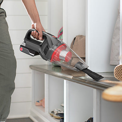 ONEPWR hand vacuum being used to vacuum spilled dirt and debris showcasing its lightweight and portable design.  