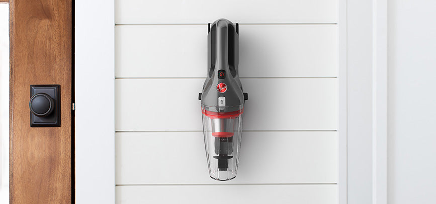 ONEPWR handheld vacuum is shown hanging on the wall mount showcasing its convenient storage.  