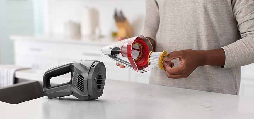 User removing the filter from the hoover handheld vacuum cleaner demonstrating easy maintenance. 