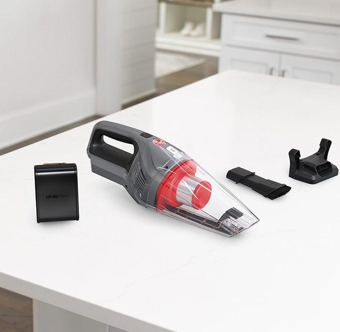 Hoover handheld vacuum cleaner shown on the kitchen countertop with included battery, charging base, and additional 2-in-1 crevice tool attachment, perfect for versatile cleaning tasks around the home.  