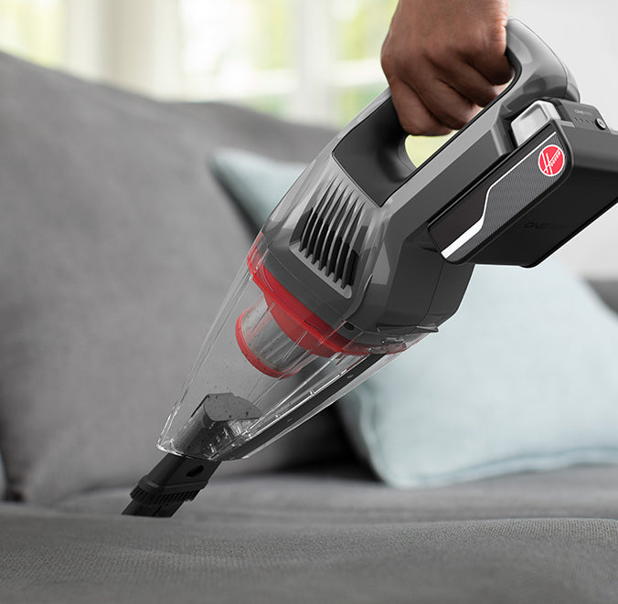 ONEPWR handheld vacuum cleaner being used to clean upholstery on a couch