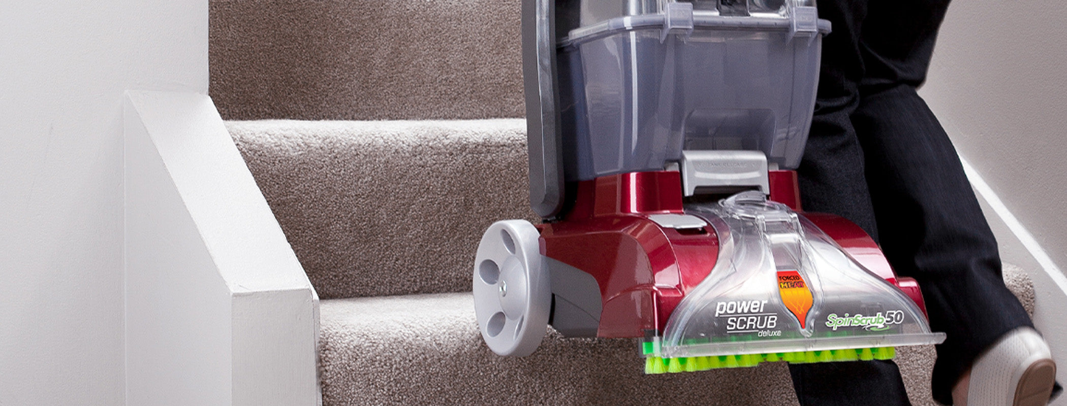 Close up of Hoover power scrub deluxe carpet cleaner being carried up the stairs highlighting its lightweight design