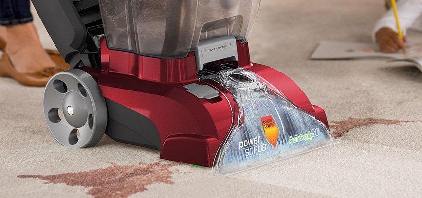 Close up of Hoover power scrub deluxe head in action, removing a deep stain from a light colored carpet 