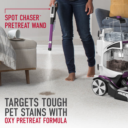 Someone using the included spot chaser pretreat wand to target tough pet stains with oxy pretreat formula