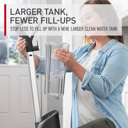 Woman inserting her larger clean water tank into her powerdash pet advanced carpet cleaner highlighting that you can now have fewer fill ups and longer clean time