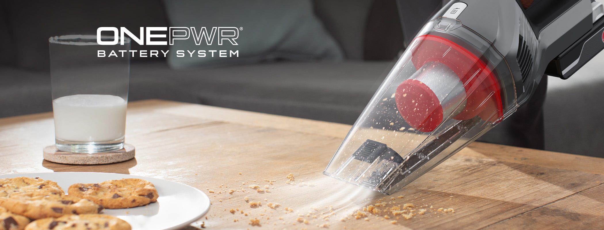 ONEPWR handheld vacuum cleaner with onepwr battery system is shown in action vacuuming cookie crumbs from coffee table showcasing powerful suction and portability for quick cleanups.