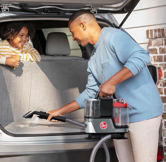 Man using the ONEPWR Cleanslate portable spot cleaner to deep clean his car interior highlighting its lightweight design and portability 