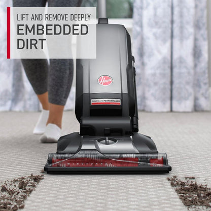 Hoover vacuum cleaner in use effectively lifting and removing deeply embedded dirt from a carpet.