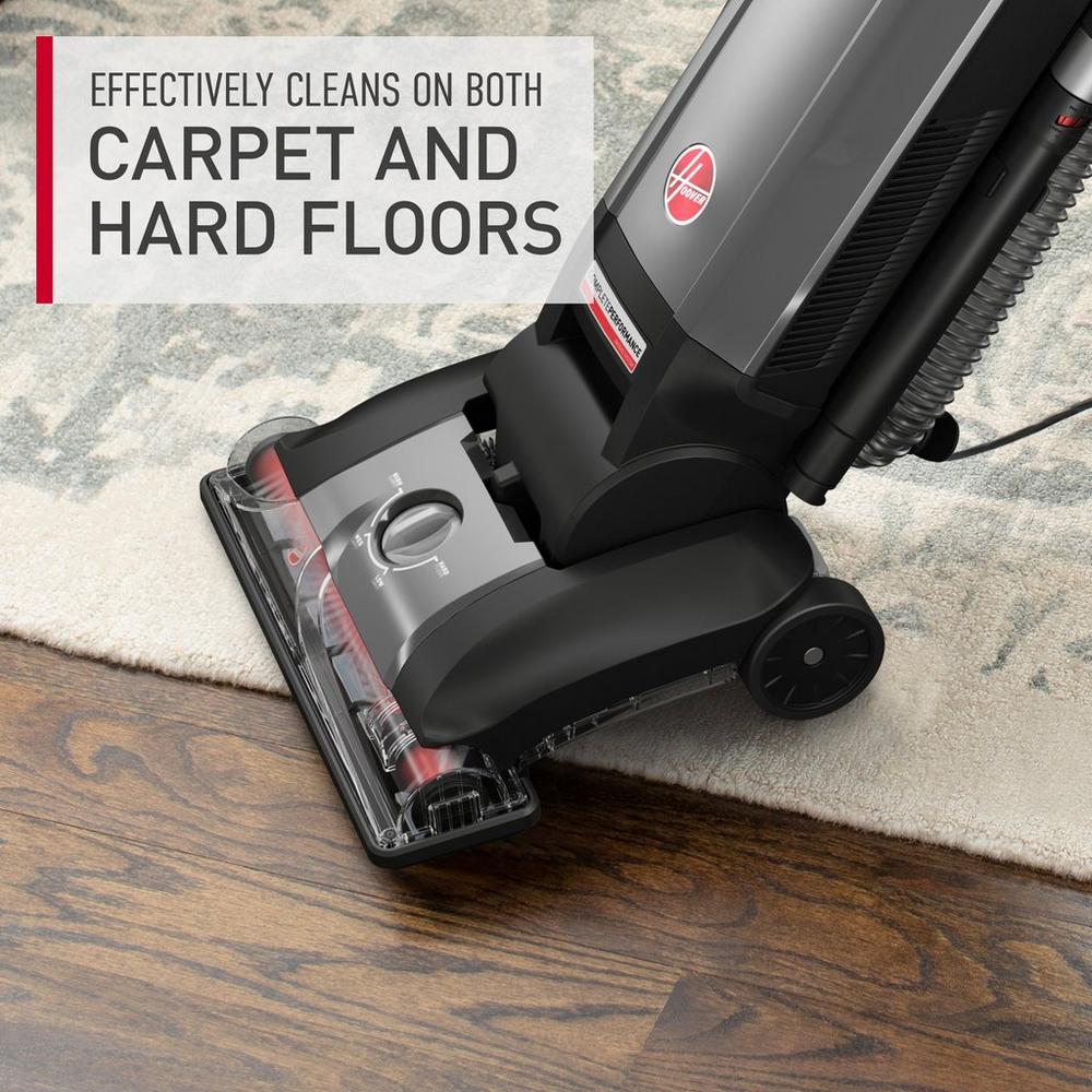 Hoover vacuum cleaner in action, vacuuming both hard floor and carpet at the same time displaying its effectiveness in cleaning multiple surface types.