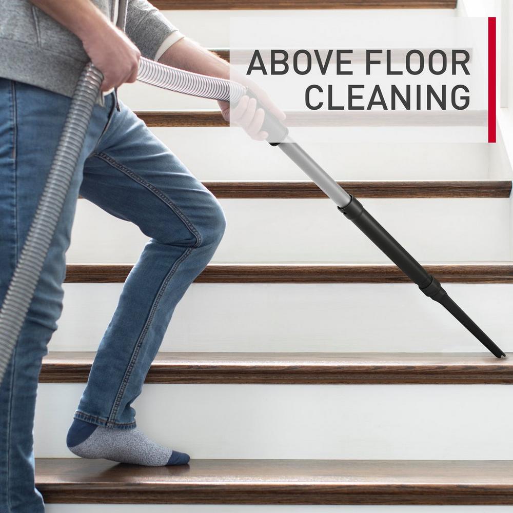 A person using the Hoover vacuum cleaner crevice tool attachment for above floor cleaning on a staircase.  