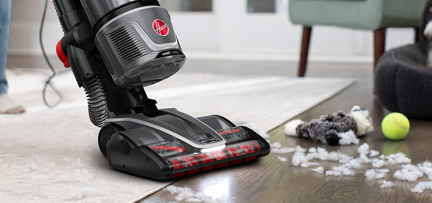 Hoover upright vacuum cleaner effectively cleaning up pet messes such as the scattered cotton from a ripped dog toy